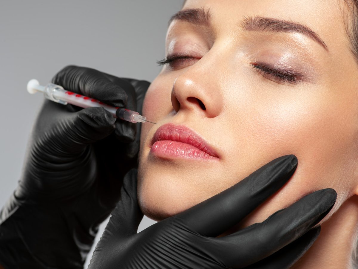 Caucasian woman getting botox cosmetic injection in the lips. Woman gets botox injection in her face